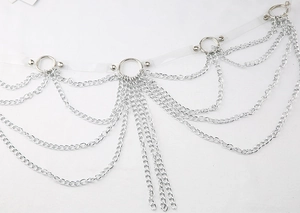 Détail de chaînes métalliques multicouches argentées et d'anneaux sur ceinture PVC