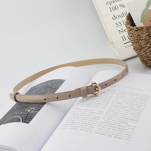 Close-up of khaki leather belt with gold round buckle on minimalist background