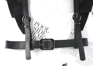 Detail of punk style PU leather body harness with dark metal buckles and eyelets