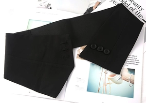 Dettaglio della cintura a corsetto larga nera con tre bottoni su tessuto twill