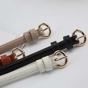 Detail of four thin leather belts in beige, black, white, and brown with gold round buckles