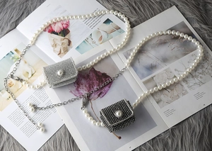 Détail de mini sacs de luxe en strass noir et blanc avec chaînes élégantes en perles