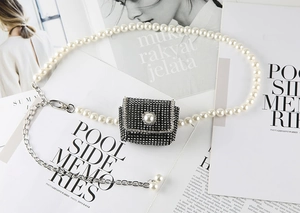 Détail d'un mini sac de ceinture en strass avec fermoir perle et chaîne de perles