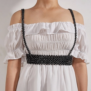Elegant black beaded body chain harness worn over a white dress for women