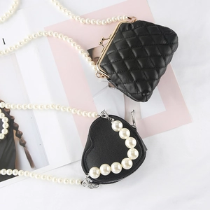Mini black quilted pearl chain bag and heart-shaped crossbody bag on a white background