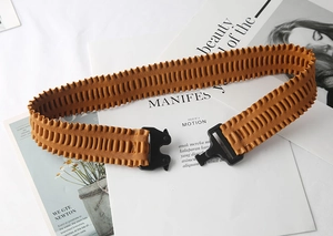Close-up of ginger yellow pleated elastic belt with black plastic tactical buckle detail