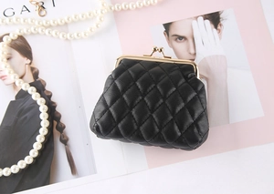 Detail of black quilted leather coin purse with vintage gold clasp and pearl chain decor