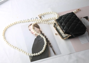 Mini black quilted leather purse featuring a white pearl chain strap and gold hardware