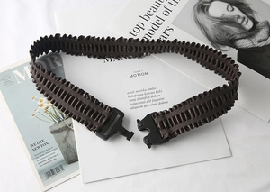 Close-up of brown wavy pleated elastic belt with a matte black quick-release buckle