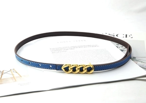 Detail of blue leather belt with contrast stitching and golden chain link buckle