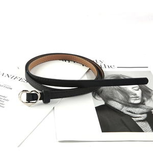 Cintura sottile vintage nera da donna con fibbia a cuore argento su sfondo di rivista di moda