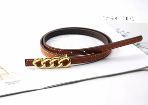 Close-up of slim brown leather belt featuring an intricate gold chain link buckle