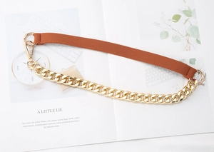 Detail of orange woven strap and chunky gold chain links with lobster clasps for bags