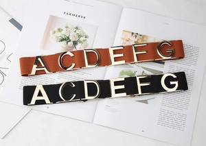 Elastic waist belts for dresses featuring gold metal letter buckles on magazine