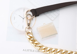 Close-up of luxury dark brown nylon webbing joined with premium gold metal chain links