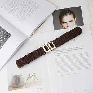 Detail of dark brown elastic waist belt featuring a vintage gold double oval buckle