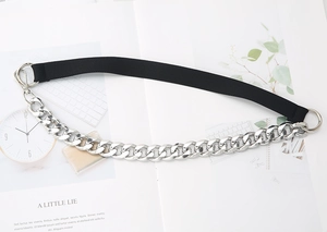 Detail of black elastic belt featuring thick silver Cuban metal chain and round ring hooks