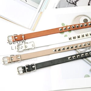 Macro shot of stylish leather skinny belts with pyramid studs in four assorted colors