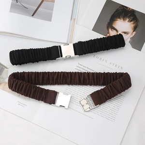 Détail de ceintures élastiques en noir et marron avec boucles rectangulaires en métal