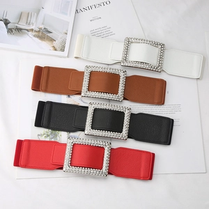 Macro shot of wide elastic waist belts with large rhinestone buckles in four colors