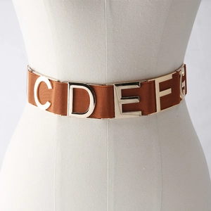 Brown elastic waist belt with gold metallic letters on a clothing mannequin