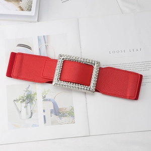 Detail of red elastic waist belt with large square rhinestone buckle on leather