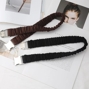 Détail des ceintures en tissu plissé extensible avec boucles carrées en métal argenté