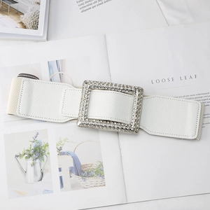 Macro detail of white elastic waist belt with luxury rhinestone encrusted rectangular buckle