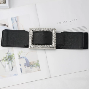 Detail view of black elastic wide belt with a luxury rhinestone encrusted buckle on magazine