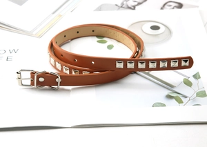 Detailed macro view of vintage brown leather waist belt with square silver metal studs