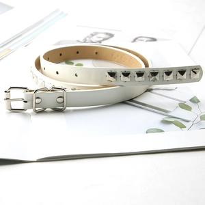 Detail of white leather skinny belt with square silver metal studs and pin buckle