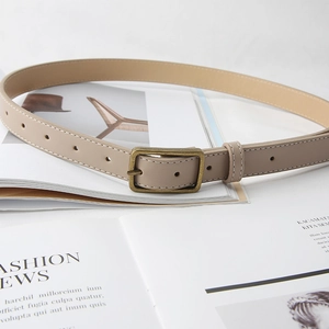 Minimalist beige leather belt with vintage bronze buckle and white stitching detail