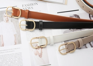 Detailed view of retro fashion waist belts with elegant gold D-shaped buckles and fine stitching
