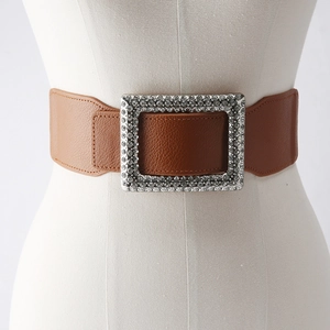 Detail of caramel brown elastic waist belt with large rectangular rhinestone buckle
