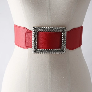 Detailed view of wide red elastic belt with sparkling rhinestone rectangle buckle