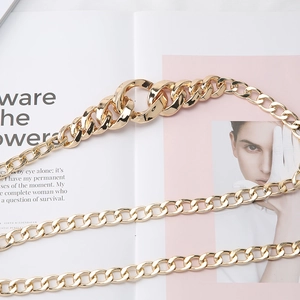 Ceinture chaîne à gros maillons dorés tendance pour robes sur un fond de magazine chic