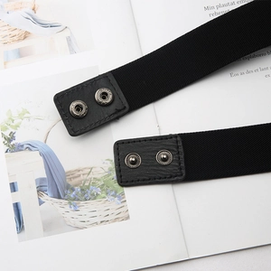Detail of black elastic waist belt featuring lychee texture leather and dual metal snaps
