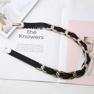 Détail d'une ceinture élastique noire avec chaîne dorée et boucle sur un magazine de mode