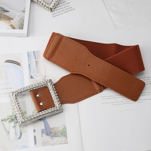 Detail of caramel brown elastic wide belt with a sparkling rhinestone square buckle