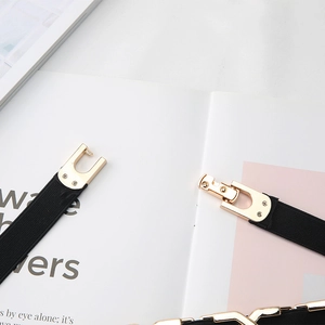 Détail de la boucle en métal doré et de la ceinture élastique noire pour femme
