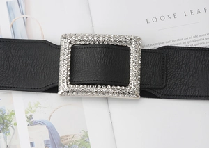 Macro shot of wide black elastic belt featuring a large rectangle rhinestone buckle
