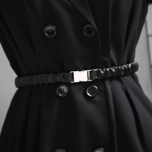 Close-up of black elastic waist belt with silver metal buckle on a double-breasted suit