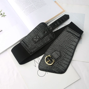Detailed macro view of black wide elastic waist belt with gold C-shape buckle and croc texture