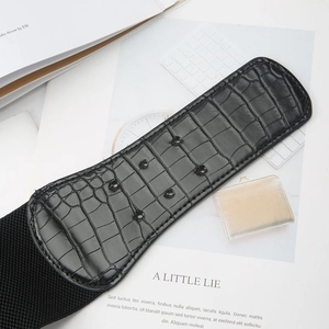 Détail de la ceinture large noire texture crocodile avec bande élastique et boucle métal