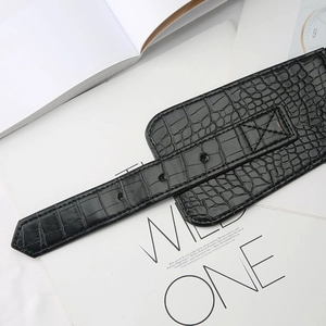 Detail of wide black elastic waist belt with faux crocodile pattern for coats and dresses
