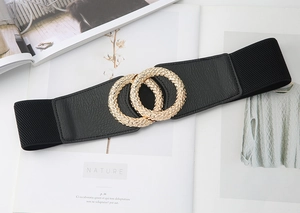 Detail of a wide elastic black belt with gold interlocking rings on a magazine