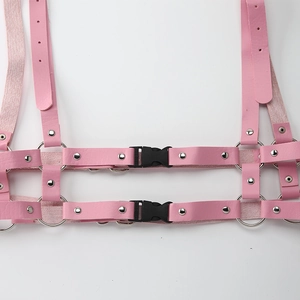 Dettaglio dell'imbracatura gotica in pelle PU rosa con fibbie nere e anelli d'argento