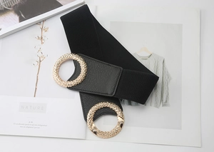 Detail of wide elastic waist belt with large textured gold rings and faux leather finish