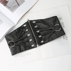 Détail d'une large ceinture en cuir PU noir avec anneaux argentés et laçage croisé chic