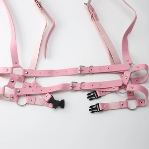 Dettaglio dell'imbracatura in pelle PU rosa con anelli in metallo argentato e fibbie